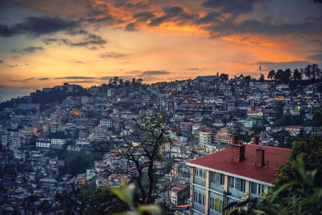 Beautiful sunset over a mountain slope engulfed with buildings in Shimla, North India