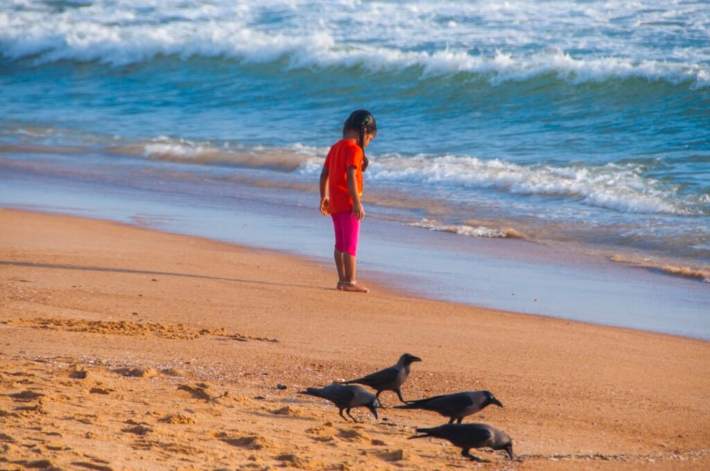 Beautiful little girl playing on the sandy beach, Goa, India,