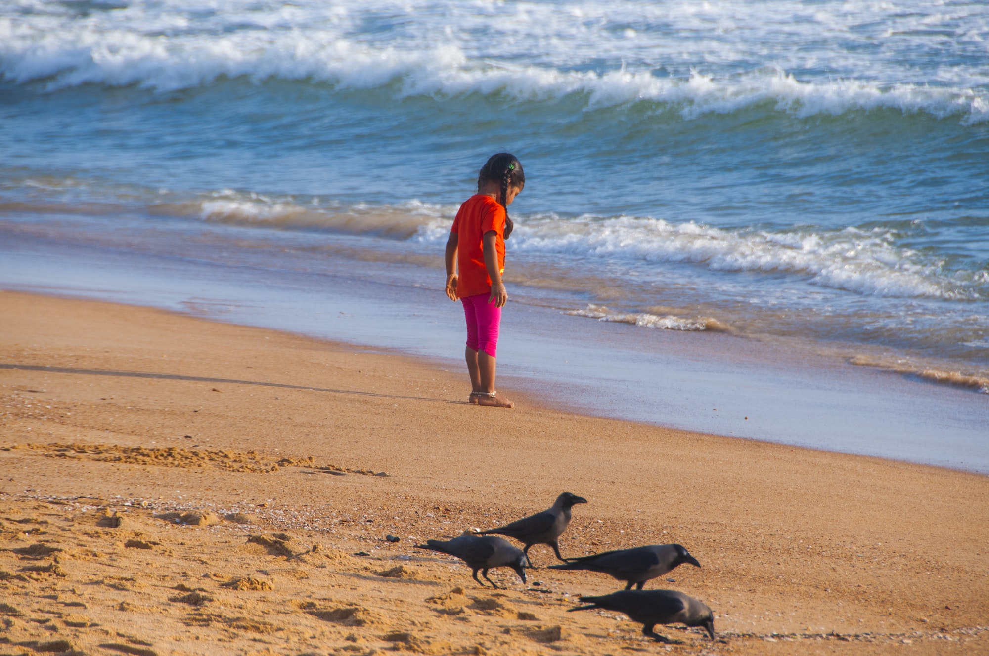 Beautiful little girl playing on the sandy beach, Goa, India,