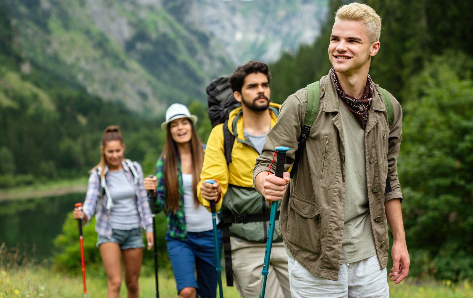 Group of friends with backpacks doing trekking excursion on mountain