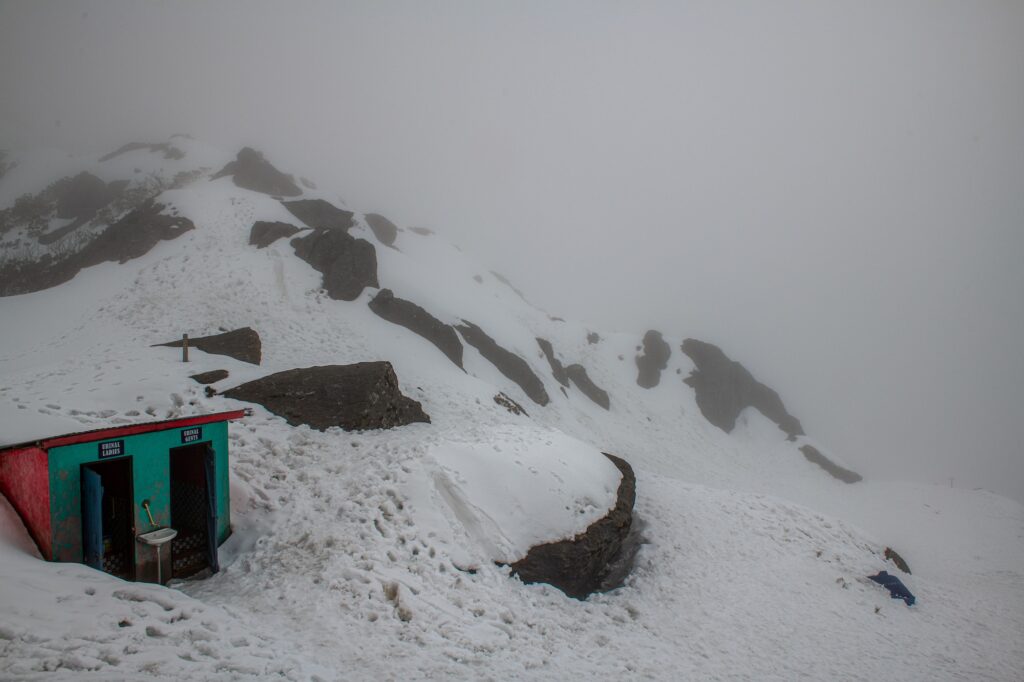 View of mountain slope with snow clad and fog near Tsomgo (Changu) Lake, in Gangtok, Sikkim, India.